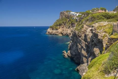Cliffs coastline with calm deep blue sea Stock Photos