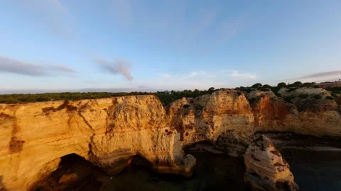 Cliffs glow amber as sun sinks behind ocean horizon Video stock 346091535
