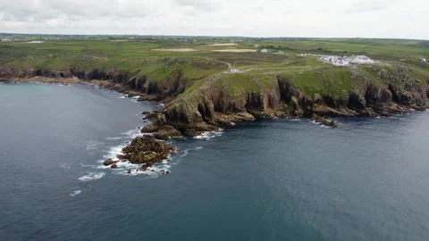 Cliffs off of Lands end with big waves and stunning scenery Cornwall UK Stock Footage 262658928