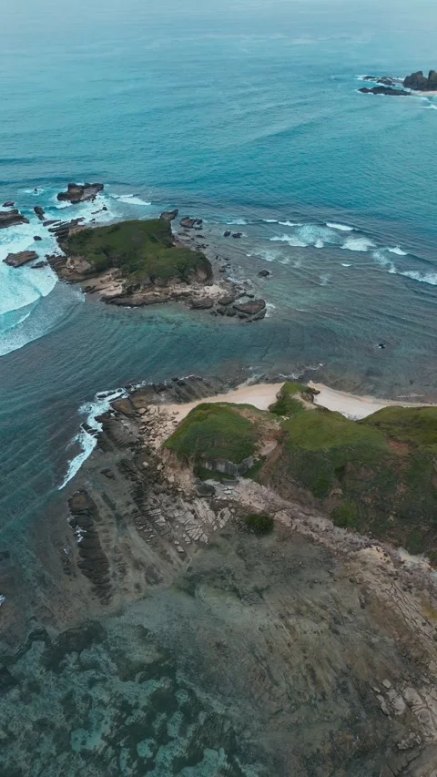 Cliffs Meet Ocean. Seaside Cliffs With Crashing Waves And Vibrant Coral Bands Vidéo 333792449