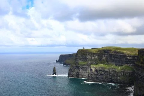 Cliffs of Moher with clouds in the sky and water under the sun in Ireland Stock Photos