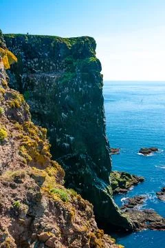 Cliffs overlooking the deep blue ocean Stock Photos