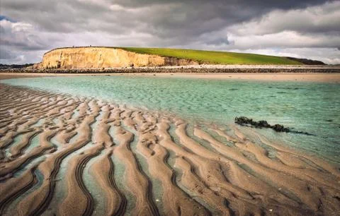 Cliffs, sand and water Stock Photos