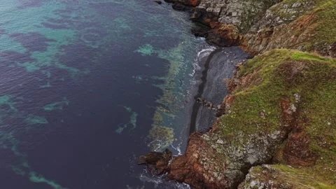 Cliffs by the sea with clear water and rocky shoreline at coastline Stock Footage 335143582