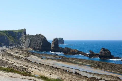 Cliffs surrounded by clear waters and blue skies Stock Photos