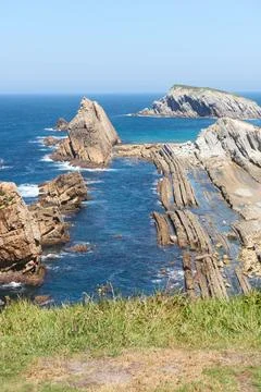 Cliffs surrounded by clear waters and blue skies Stock Photos
