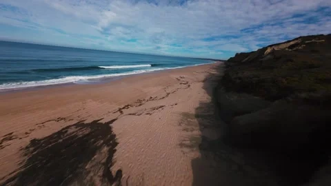 Cliffside beach scene with ocean waves and sandy shores Stock Footage 340905428