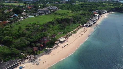 Cliffside Beach with Umbrellas and Ocean Waves on Bali Coastline Stock Footage 341920488