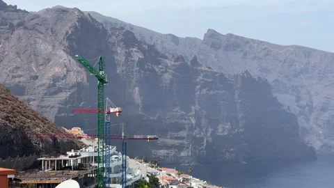 Cliffside Construction featuring a Tower Crane situated prominently by the Stock Footage 317073331