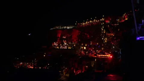 Cliffside nightlife scene glows with warm lanterns red lighting and bohemian dec Stock Footage 310820955