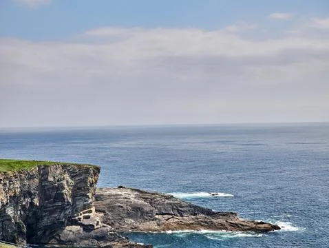 Cliffside Ocean View Under a Cloudy Sky Stock Photos