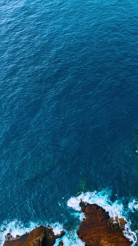 Cliffside road with crashing waves and deep blue ocean. Vertical video. Stock Footage 319759958