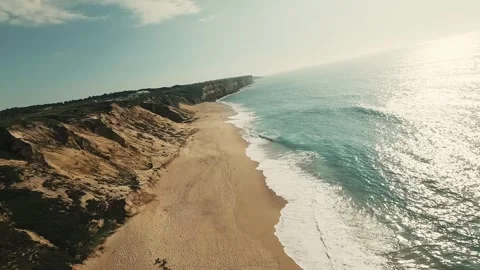 Cliffside road winds through grassy hills overlooking ocean waves Stock Footage 340226029