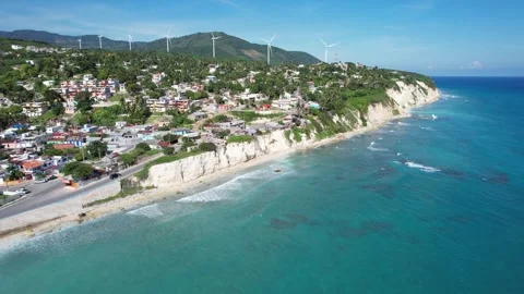 Cliffside town with wind turbines above a beach, aerial view Stock Footage 278369853
