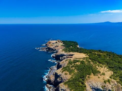 Cliffside view of ocean at a remote coastline under clear blue sky during d.. Stock Photos