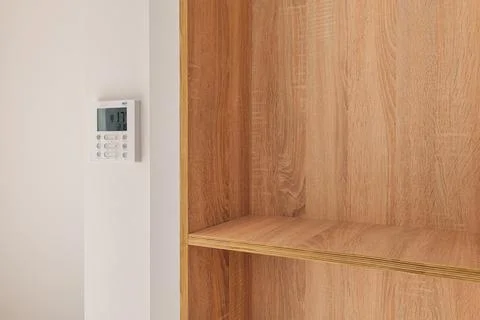 Climate control panel on the wall in a room with wooden built-in furniture with Фото