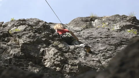 Climber ascending the rock mountain wall Stock Footage 208939191