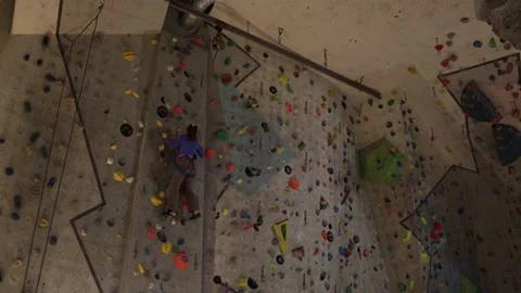 Climber ascends indoor wall with rope Stock Footage 339287858