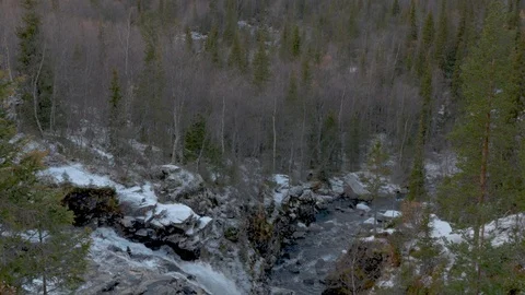 Climber with a backpack stands over a cliff in the mountains. Below the Stock Footage 97998894