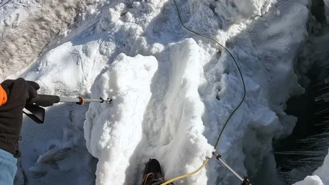 Climber in a bundle is walking along a snow bridge past deep cracks Vídeo Stock 208437799