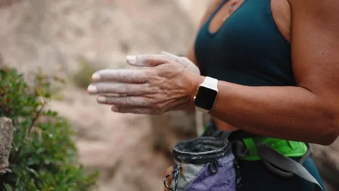 Climber clapping chalk on her hands at a rock face Stock Footage 346182646