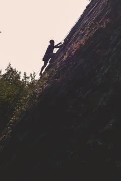 A climber climbing a mountain Stock Photos