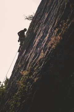 A climber climbing a mountain Stock Photos