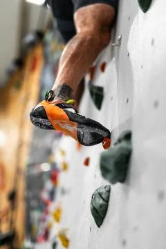 Climber climbing shoe in a hold while traversing, indoor climbing gym Foto stock