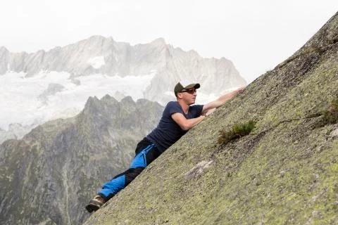 Climber climbs on a sloping rock wall in the Swiss mountains Foto stock