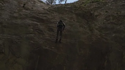 Climber Descending Steep Mountain Cliff Edge in Romania Stock Footage 345632515