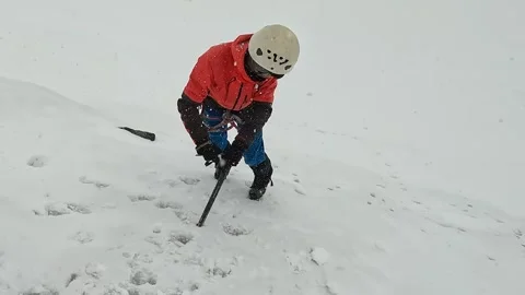 Climber descends down the slope with the help of an ice axe Stock-Footage 246292370