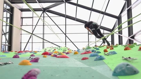 A climber descends from an indoor climbing wall. Stock Footage 300503568
