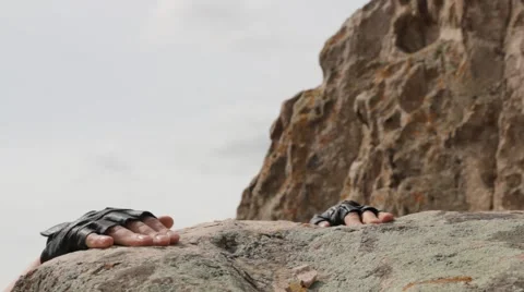 Climber on edge of cliff serves a helping hand Stock Footage 62389668