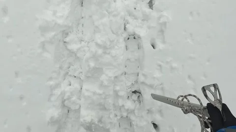 Climber with an ice axe in his hand walks along a snowy slope Stock-Footage 246292333