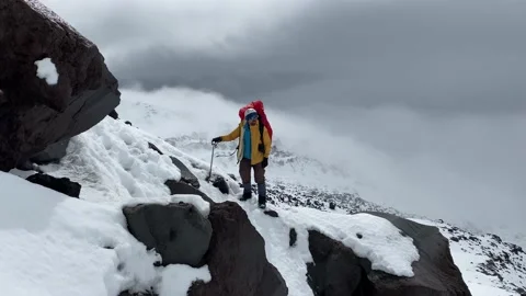 Climber with a large backpack stands on the slope of a volcano Stock Footage 141050194