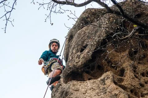 A climber looking down from the top of the cliff. Stock Photos