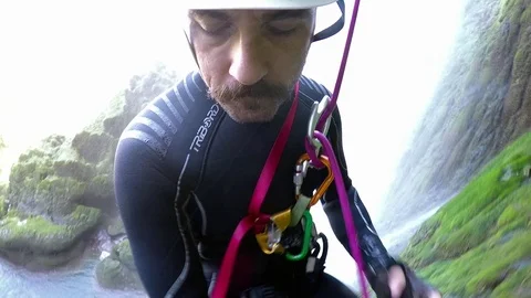 Climber man rappel from a high waterfall Stock Footage 70748963
