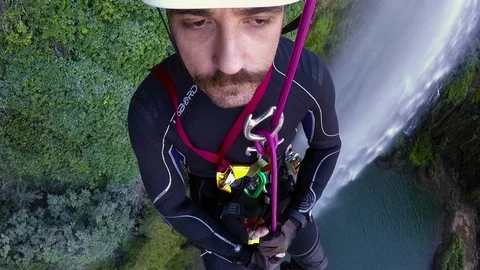 Climber man rappel from a high waterfall Video stock 70749637