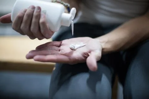 Climber man using liquid chalk magnesium preparing to climb indoor, close-up Foto stock