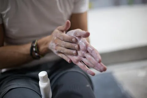 Climber man using liquid chalk magnesium preparing to climb indoor, close-up Stock Photos