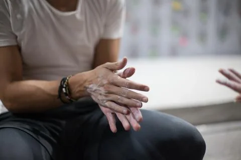 Climber man using liquid chalk magnesium preparing to climb indoor, close-up Foto stock