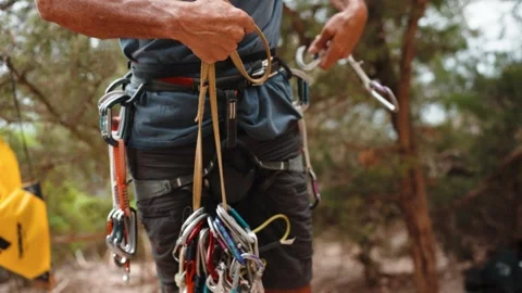 Climber Organizes Slings and Quickdraws on Harness in Forest Stock Footage 346497749