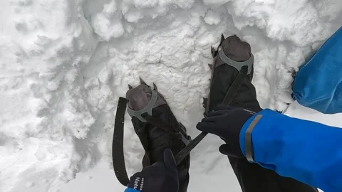 Climber puts on soft climbing crampons. View of the legs Video stock 246292869