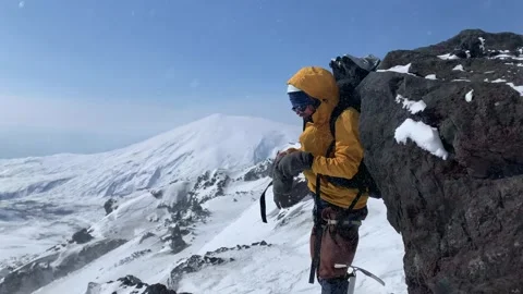 The climber puts on warm mittens during strong winds and snowfalls Stock-Footage 140373882