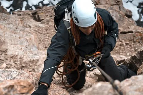 Climber is rappeling from the mountains summit. Stock Photos