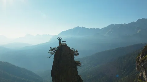 A climber reaches the top of a small peak Vídeos de archivo 101899994