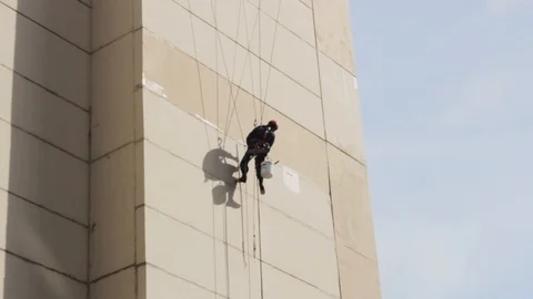 Climber repairs a wall suspended on four cables Stock-Footage 108560306