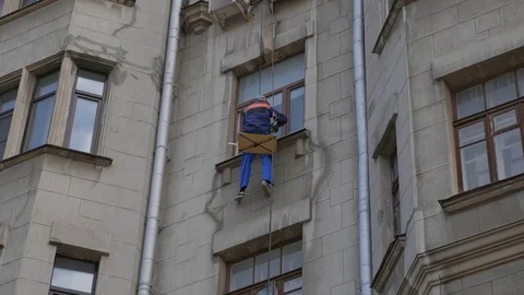 Climber spends repair work on a multi-storey building height Stock Footage