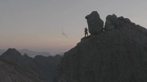 Climber throws abseil rope from the In Pinn, Cuilin RIdge, Skye, Sunrise Stock Footage 314193609