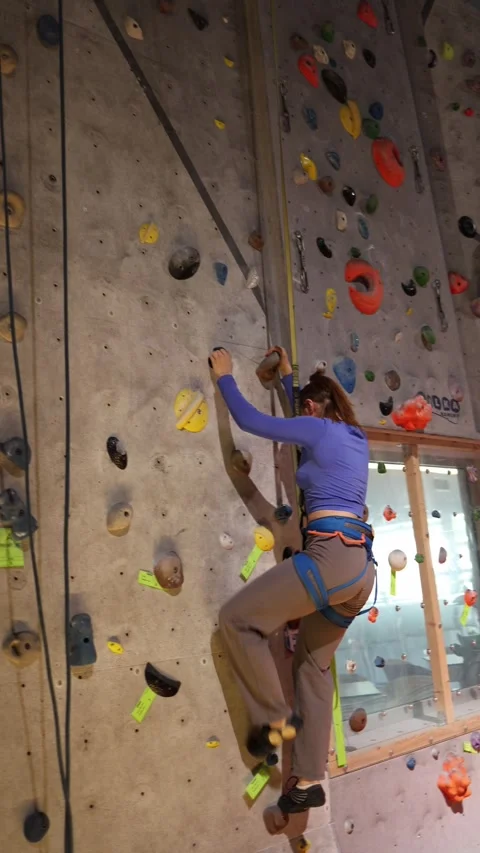 Climber trains technique on an indoor climbing wall Stock Footage 339287691